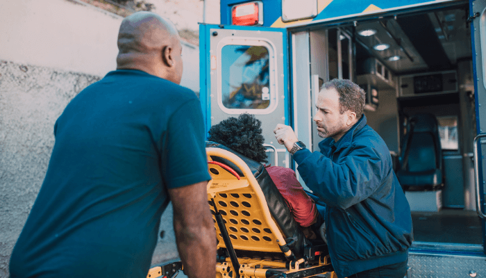 two paramedics giving emergency medicine to injured woman